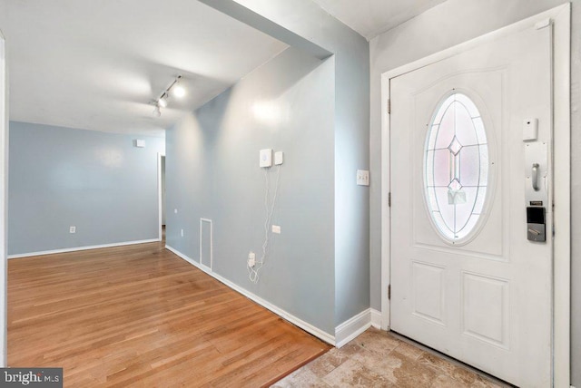 foyer entrance featuring rail lighting and light wood-type flooring