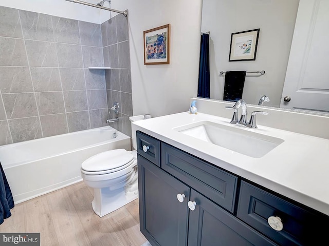 full bathroom featuring hardwood / wood-style floors, shower / tub combo with curtain, vanity, and toilet