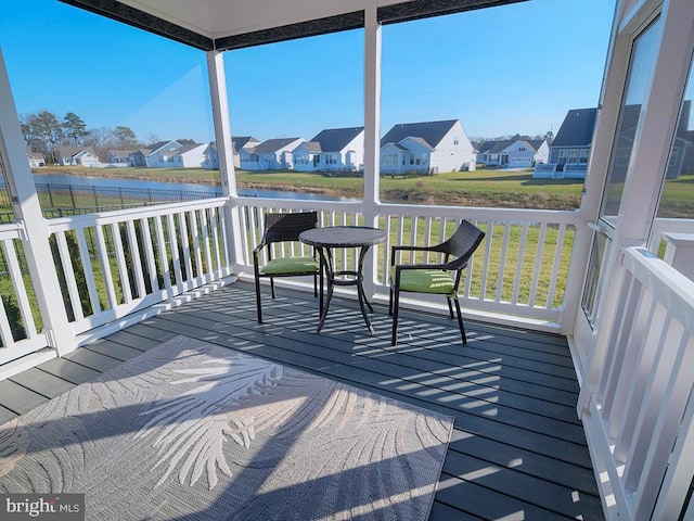 sunroom featuring a wealth of natural light and a water view