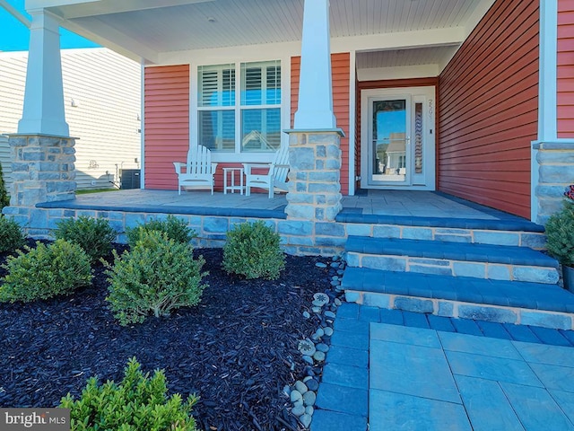 doorway to property with a porch and central AC unit