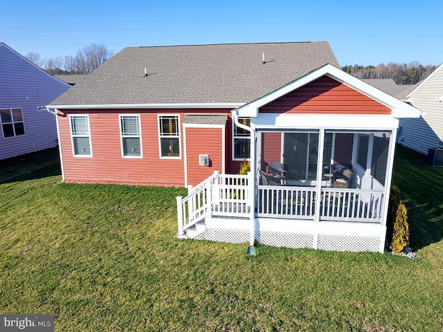 rear view of property with a yard, a sunroom, and a wooden deck