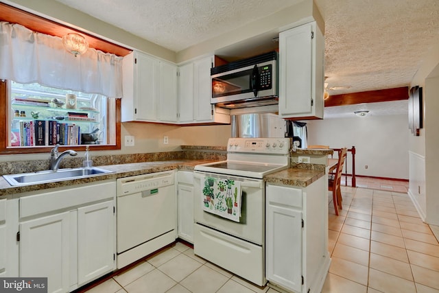 kitchen featuring white appliances, white cabinetry, sink, and a textured ceiling