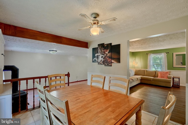 dining room with a textured ceiling, light tile patterned floors, and ceiling fan