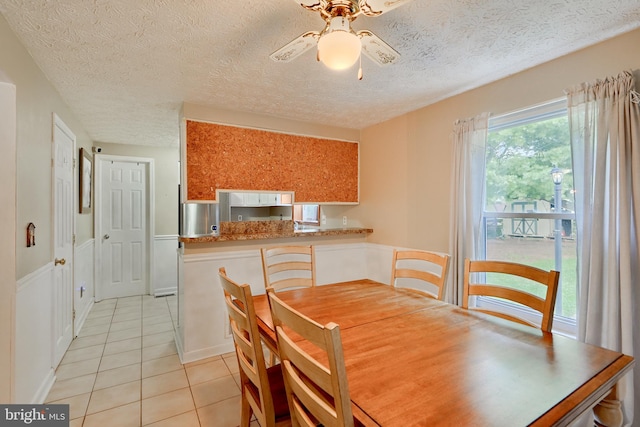 dining room featuring light tile patterned flooring, ceiling fan, and a textured ceiling