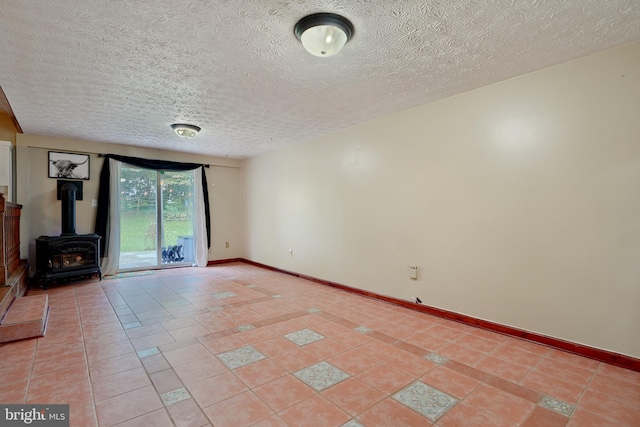 unfurnished living room featuring a wood stove, light tile patterned flooring, and a textured ceiling