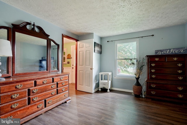 bedroom featuring wood-type flooring and a textured ceiling