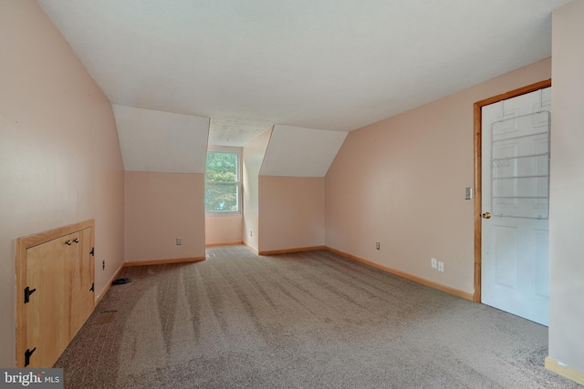 additional living space featuring vaulted ceiling and light carpet