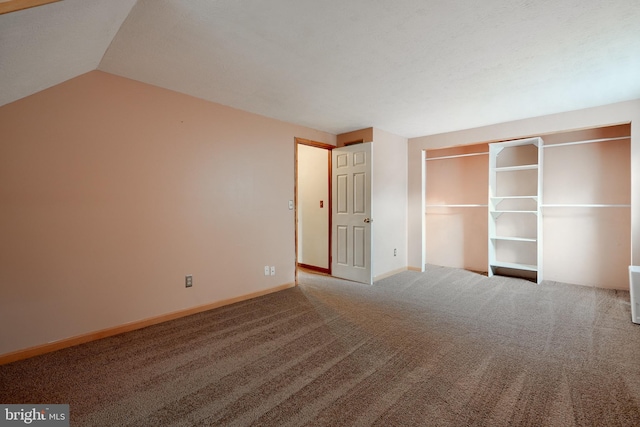 unfurnished bedroom featuring carpet flooring, a closet, and lofted ceiling