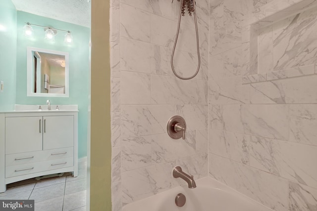 bathroom featuring a textured ceiling, vanity, tiled shower / bath combo, and tile patterned floors