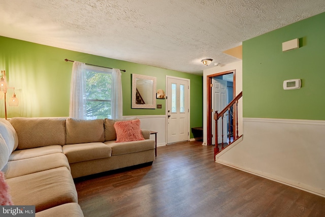 living room with a textured ceiling and dark hardwood / wood-style floors