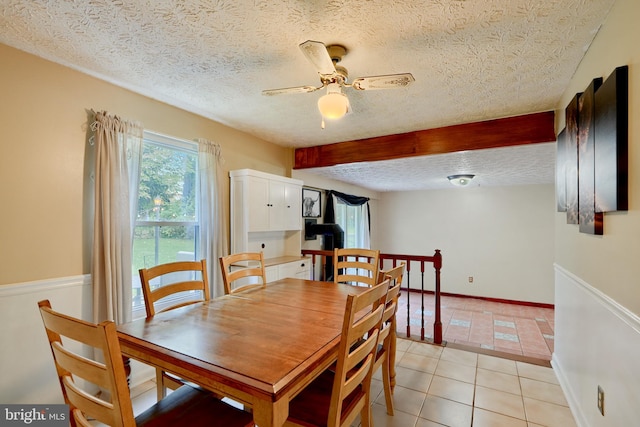 dining space with a textured ceiling, ceiling fan, and light tile patterned flooring