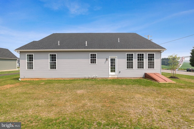 rear view of property with a yard