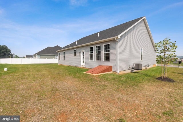 back of property with cooling unit and a yard