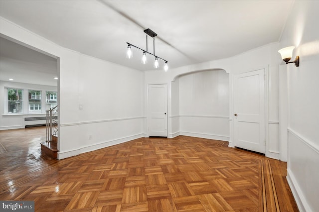 spare room featuring parquet flooring and a baseboard radiator