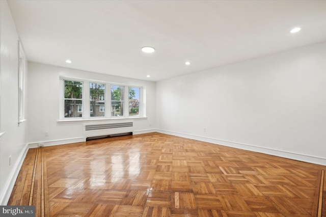 unfurnished room featuring a baseboard radiator and light parquet flooring