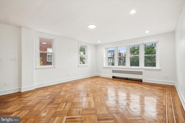 empty room with radiator heating unit and light parquet floors