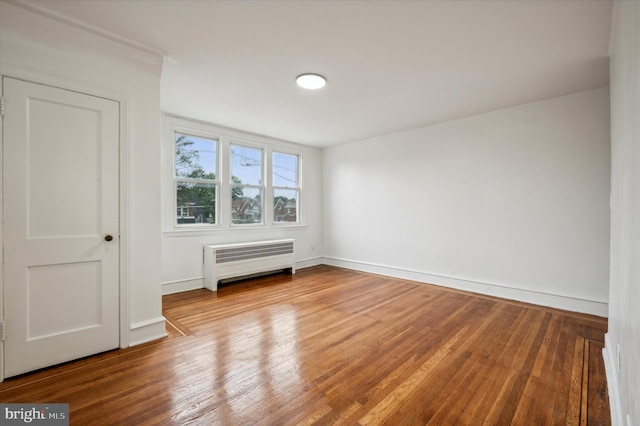 spare room featuring radiator and hardwood / wood-style floors