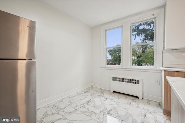 unfurnished dining area featuring radiator