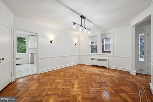 spare room featuring radiator heating unit, parquet floors, and a baseboard heating unit