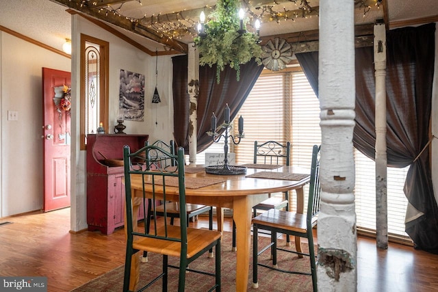 dining space featuring wood finished floors and ornamental molding