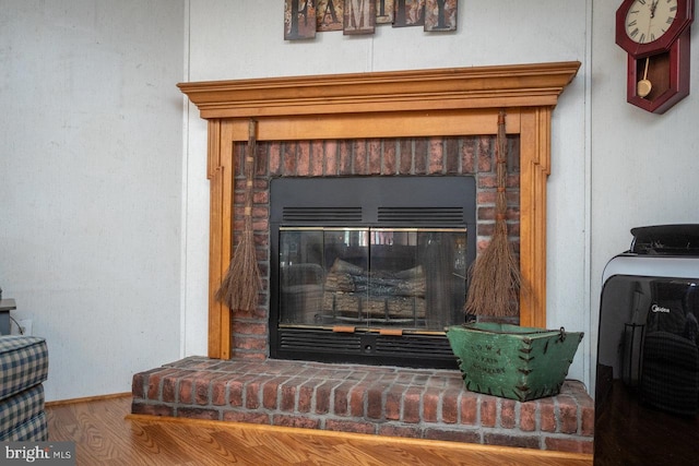 details with a brick fireplace and hardwood / wood-style floors