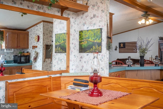 kitchen with black microwave, a textured ceiling, wallpapered walls, and lofted ceiling with beams