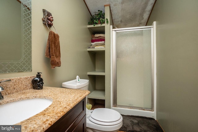 bathroom with a textured ceiling, walk in shower, vanity, and toilet