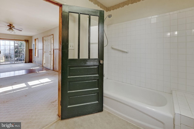 bathroom with ceiling fan and tiled shower / bath