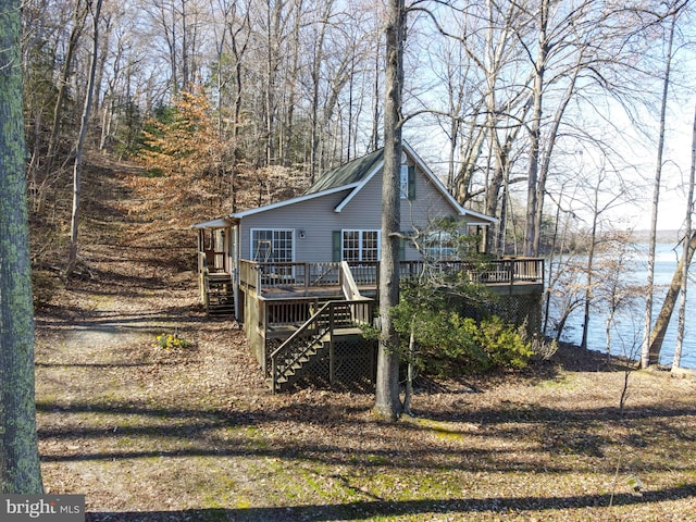 back of property featuring a deck with water view