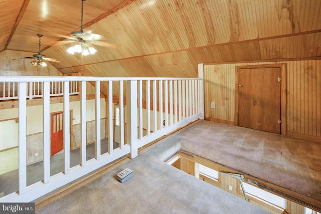 interior space with wooden walls, vaulted ceiling, ceiling fan, and wooden ceiling