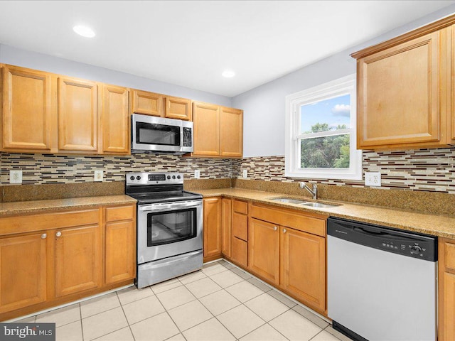 kitchen with light tile patterned floors, appliances with stainless steel finishes, tasteful backsplash, and sink