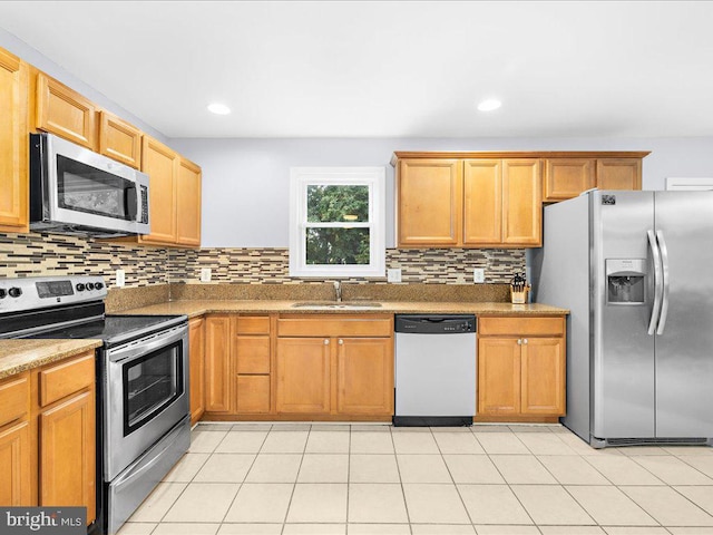 kitchen with light tile patterned floors, appliances with stainless steel finishes, sink, and decorative backsplash