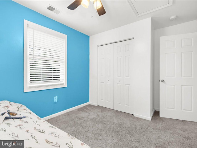 unfurnished bedroom with ceiling fan, light colored carpet, and a closet