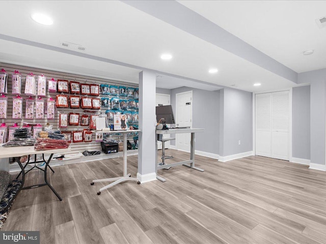 exercise room with light hardwood / wood-style flooring