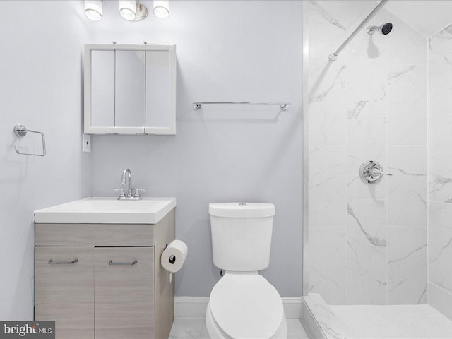 bathroom featuring vanity, toilet, and tiled shower