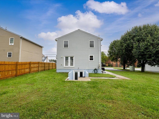 rear view of house with a lawn and a patio area