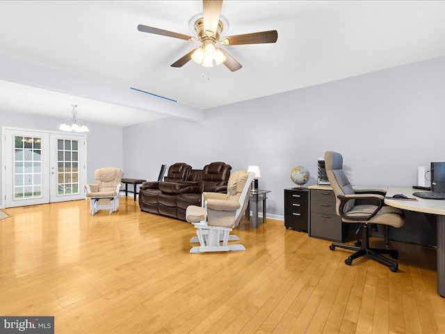 home office with ceiling fan with notable chandelier and hardwood / wood-style floors