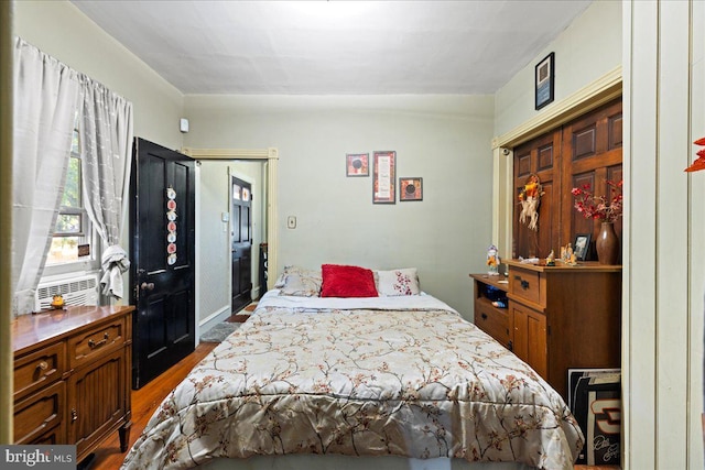 bedroom with dark hardwood / wood-style flooring