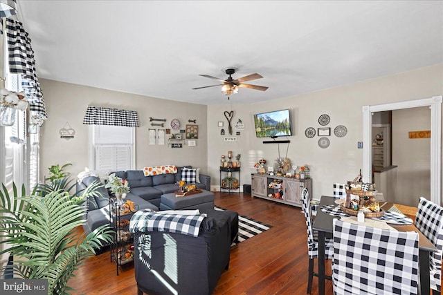 living room featuring ceiling fan and dark wood-type flooring