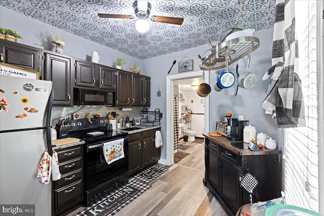 kitchen featuring light hardwood / wood-style floors, sink, backsplash, black appliances, and ceiling fan