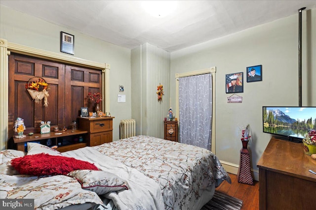 bedroom with radiator and dark hardwood / wood-style floors