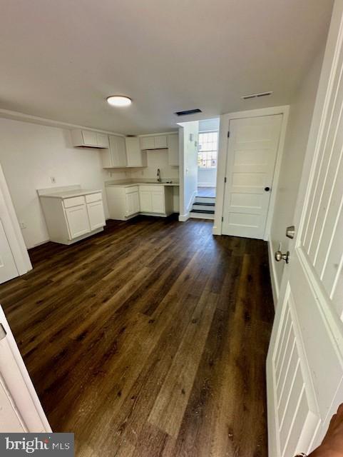 unfurnished living room featuring dark hardwood / wood-style floors and sink