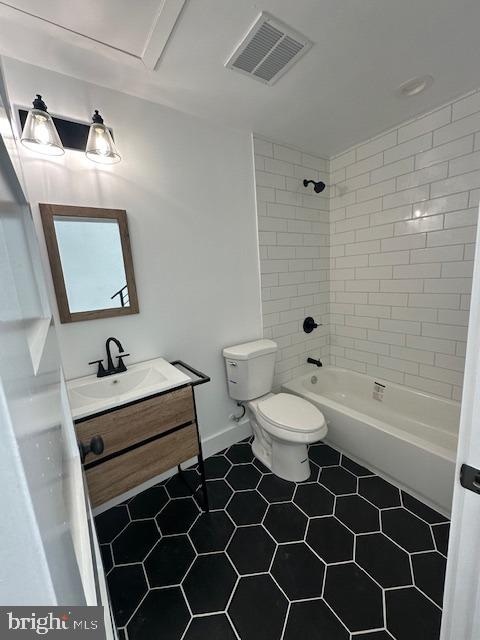 full bathroom featuring tiled shower / bath combo, vanity, and toilet