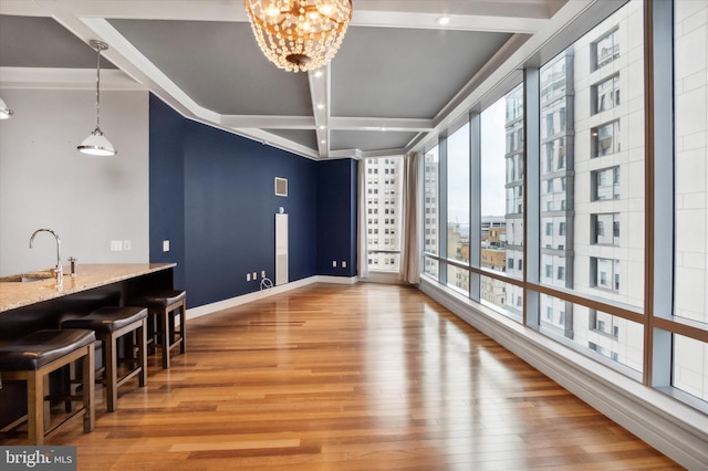 dining area with light wood-type flooring, sink, and a notable chandelier