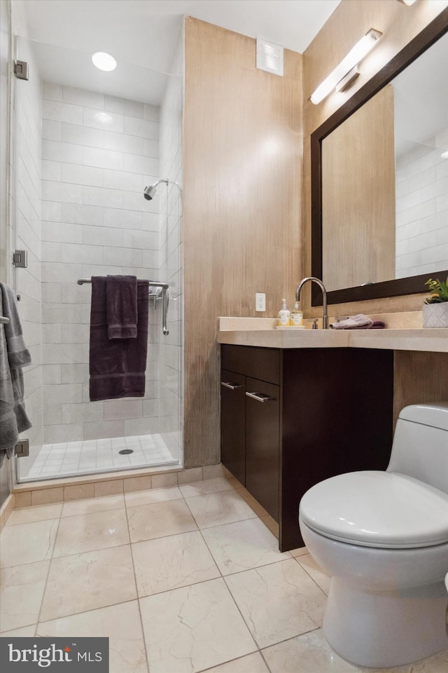 bathroom featuring a shower with door, vanity, and toilet