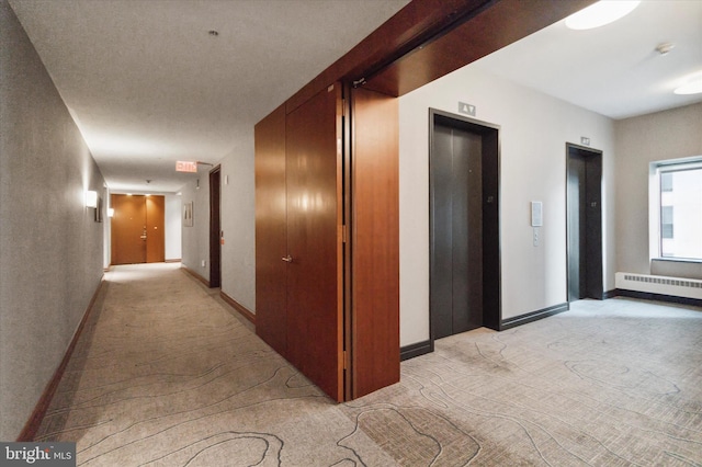 hall featuring light colored carpet, radiator, and elevator