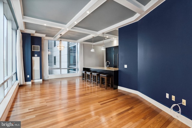 unfurnished room with coffered ceiling, sink, beamed ceiling, and hardwood / wood-style flooring