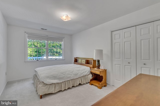 bedroom with a closet and light colored carpet