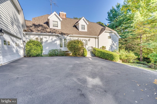 11160 Cove Lake Rd, Lusby, MD 20657 - new england style home with roof with shingles, a chimney, a garage, and driveway