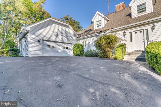 11160 Cove Lake Rd, Lusby, MD 20657 - view of front facade featuring a garage and a chimney